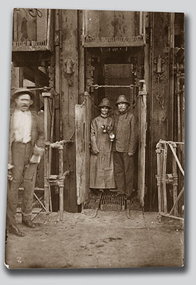 Charles Evans Hughes and his wife, Antoinette, gamely pose for a press photographer on August 12, 1916, after their hour-long copper mine tour for which they were fully outfitted in protective clothing, helmets, and gas lanterns. 