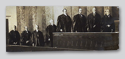 Clinedinst’s “Opening of U.S. Supreme Court” depicts from right to left, by seniority: Chief Justice Melville W. Fuller, and Associate Justices John Marshall Harlan, David J. Brewer, Edward D. White, Rufus W. Peckham, Joseph McKenna, William R. Day, and Oliver Wendell Holmes, Jr.